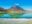 A still, emerald, turquoise lake in front of a volcano
