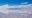 Vast salt flats interspersed with little cones of salt under a blue sky dotted with cloud tufts