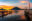 Golden sunset glow across lake with two wooden piers with uneven poles in foreground and volcano beyond