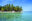 palm tree fringed tropical island with clear blue sea and white sand beach