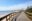 Long boardwalk over sands at Punta del Este, with city and skyscrapers in background